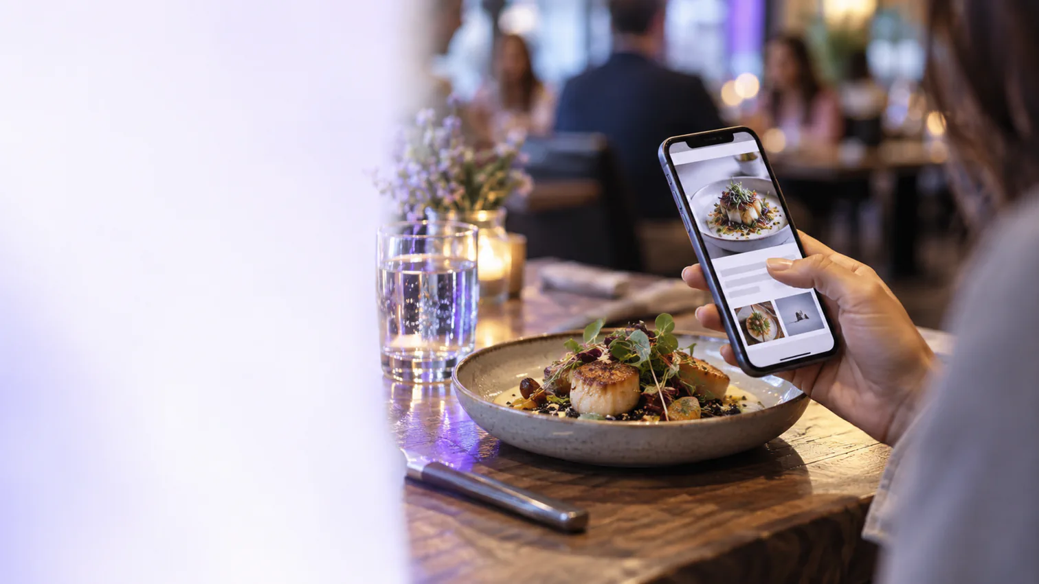 A diner uses a restaurant website on a phone while choosing a meal.